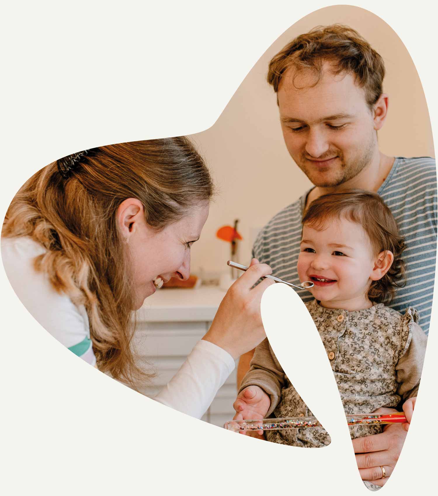Zahnärztin mit Kind und Vater in Behandlung